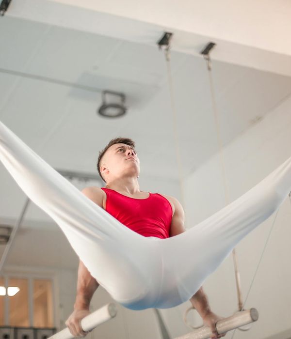 Чоловік виконує контрольовану силову вправу в темному залі.